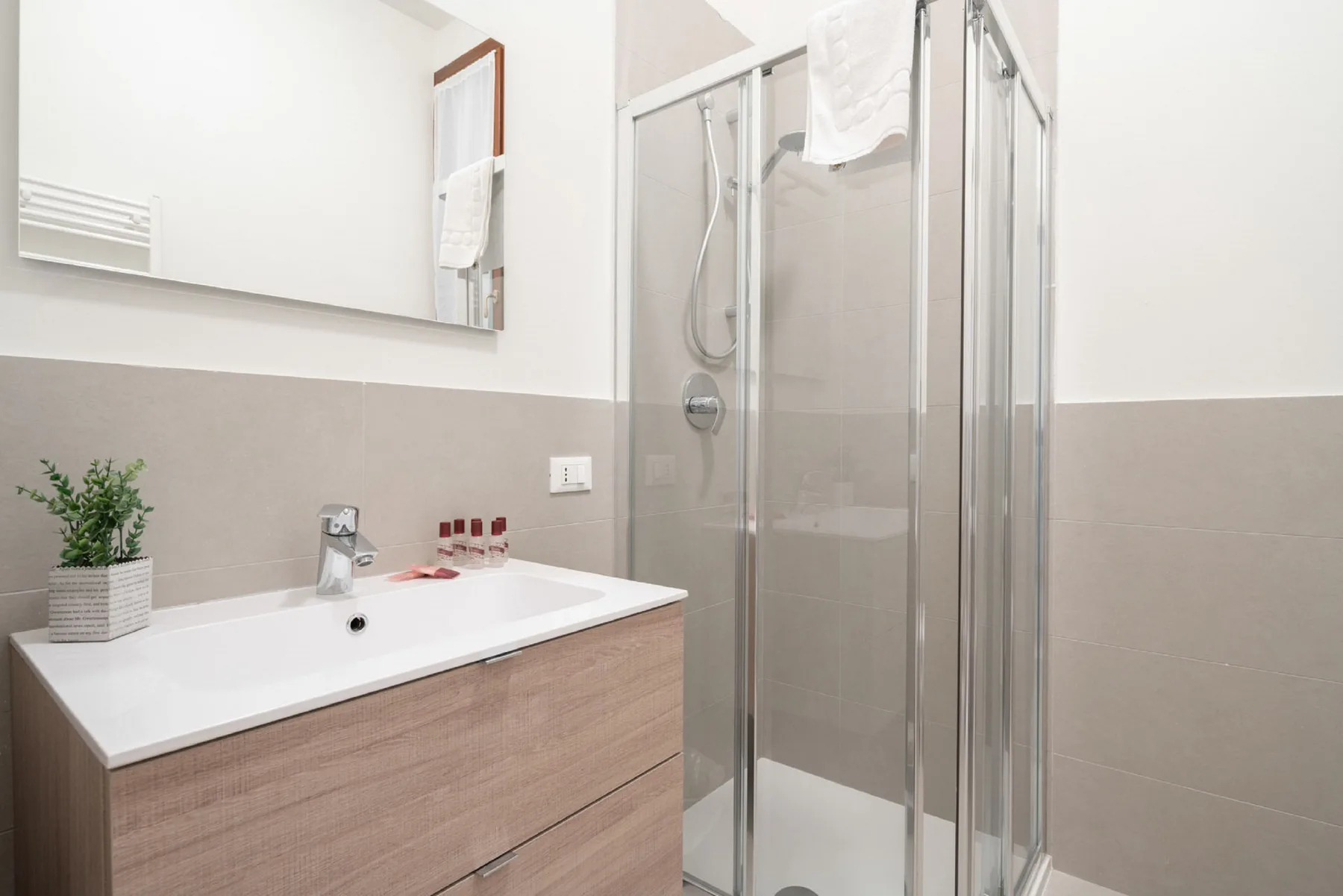 Un baño luminoso con lavabo y ducha de cristal.