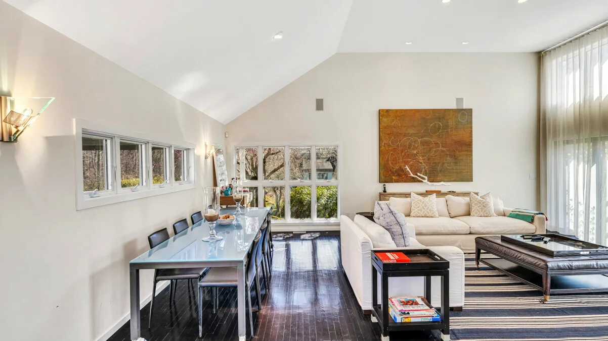 A bright open-plan living and dining room with a large window.