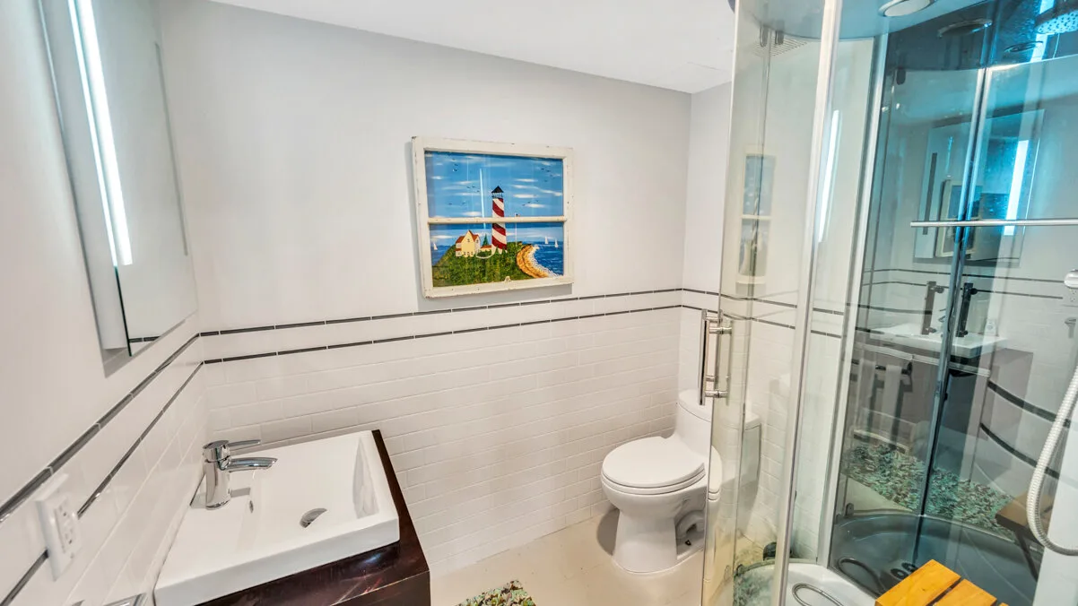 A bathroom with a sink, toilet, and glass-enclosed shower.