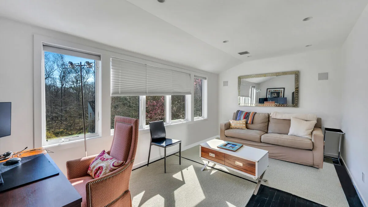 A bright living room with seating around a coffee table and large windows.