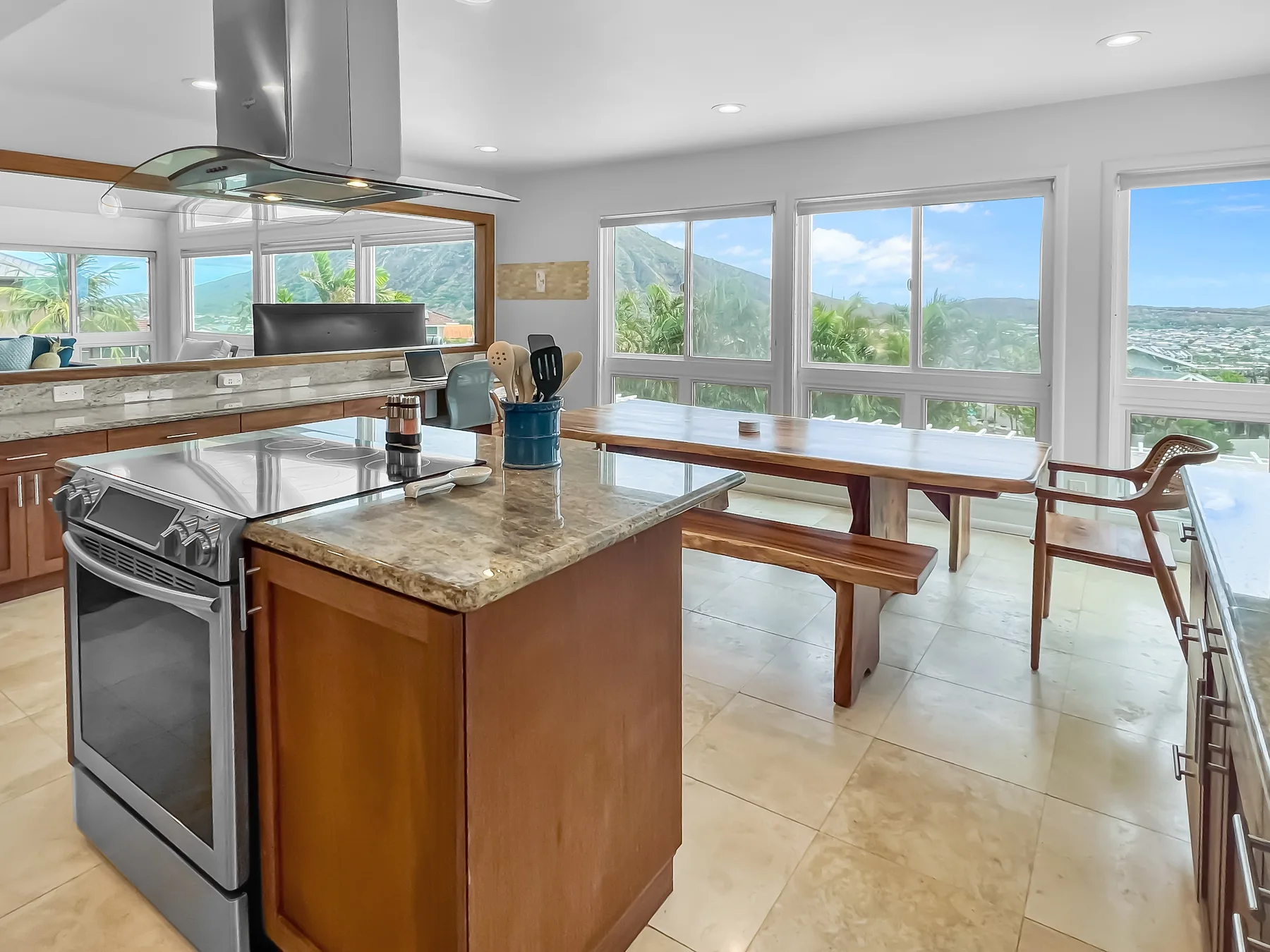 Una cocina luminosa con una isla central y una larga mesa de madera.