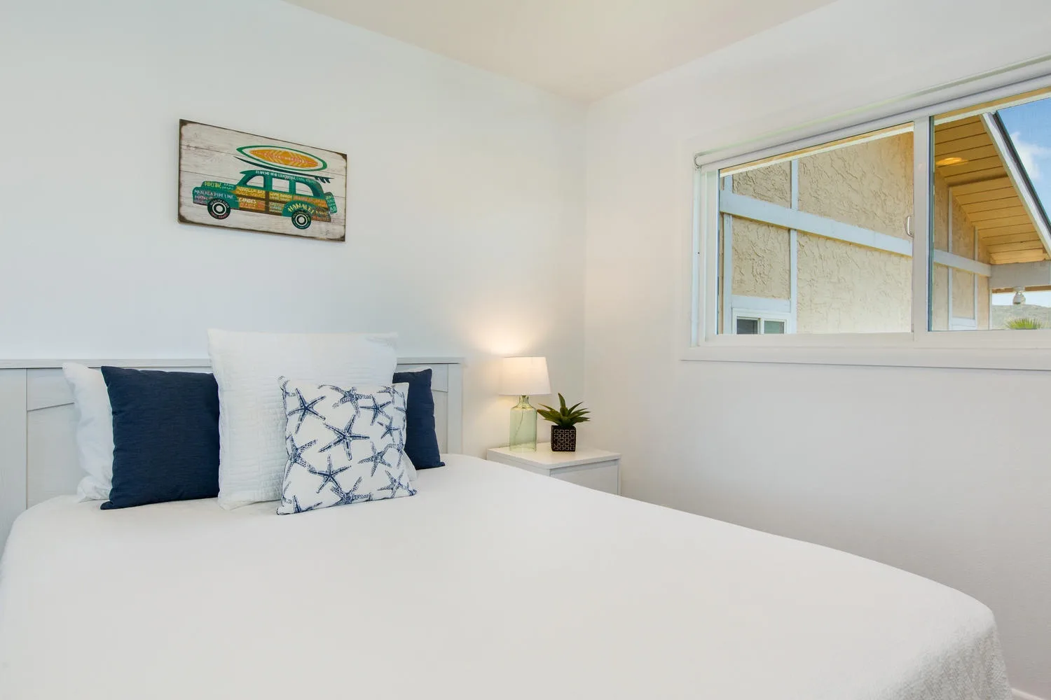 Un dormitorio luminoso con una cama bien tendida y una ventana.