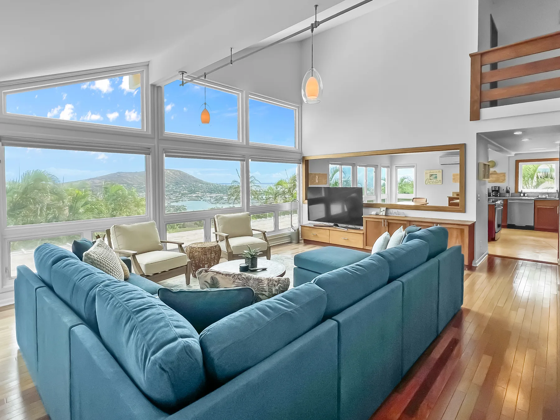 Una sala luminosa con asientos azules y grandes ventanas con vista a un lago.