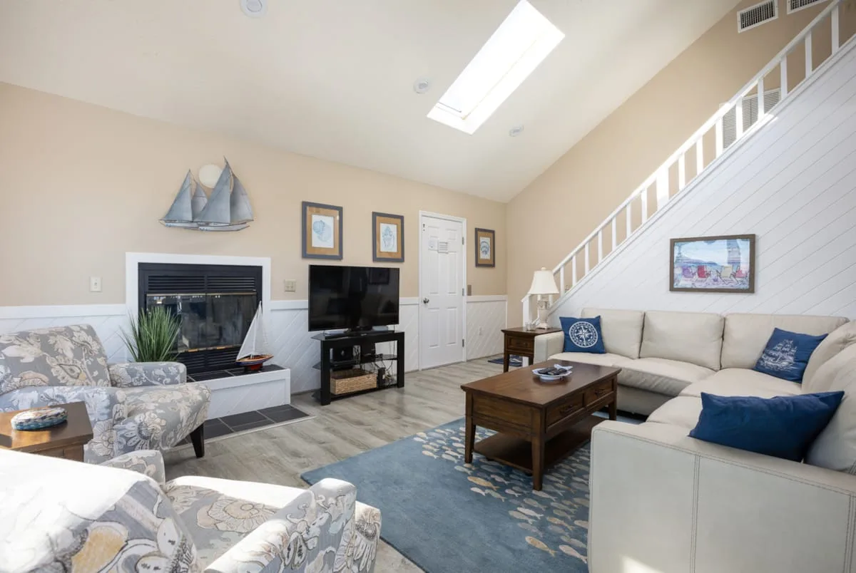 A living room with seating, a fireplace, and a wooden coffee table.