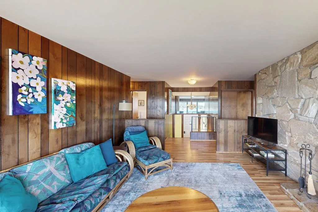 Una sala con paredes de madera tiene asientos dispuestos alrededor de una mesa baja.