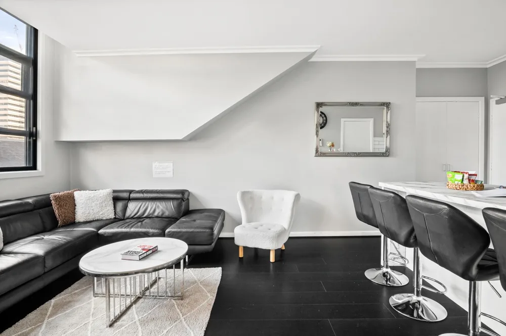 Sala de estar con asientos junto a una barra de comedor.