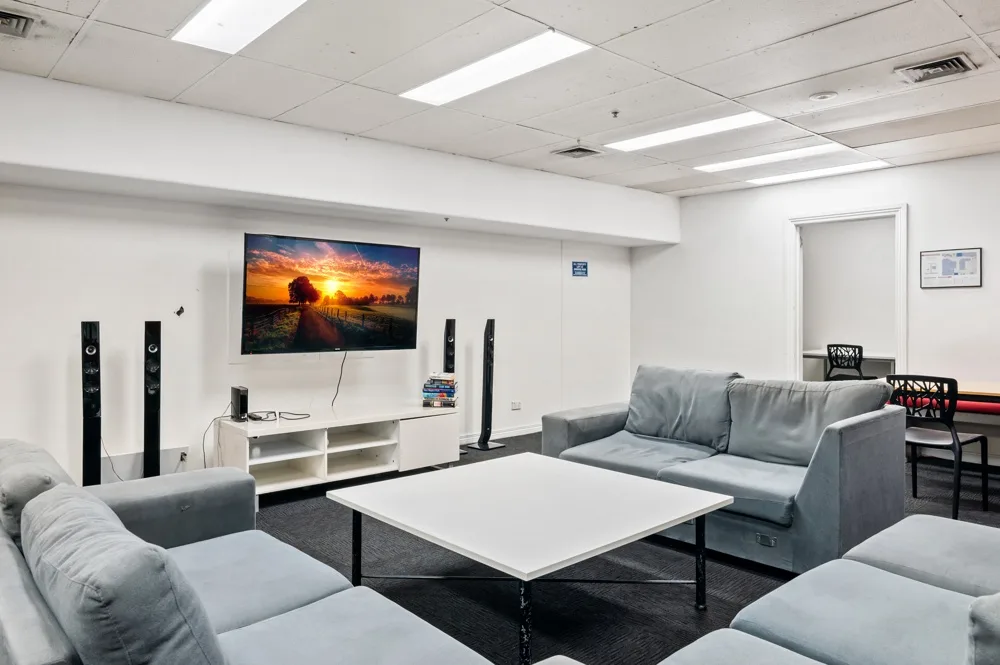 Sala de estar con asientos grises y una mesa baja blanca.