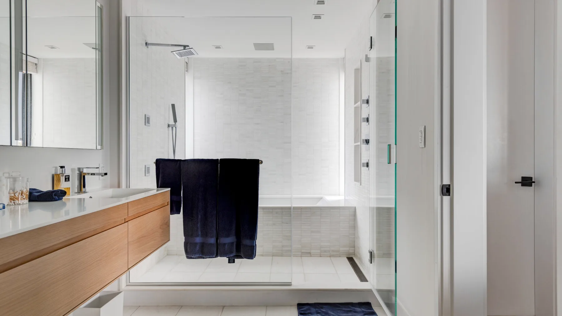 A modern bathroom with a vanity and a walk-in shower.