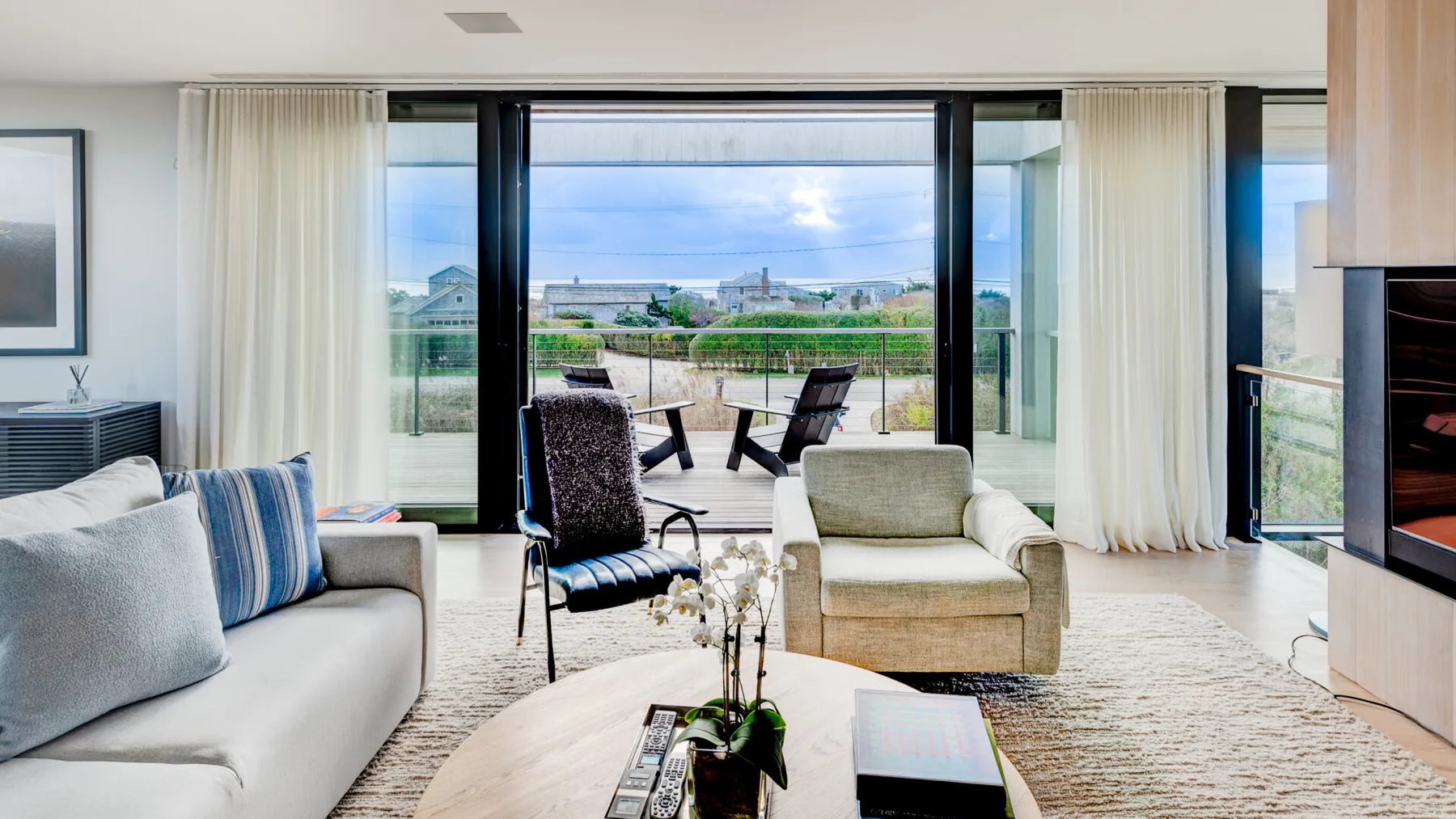 A bright living room opens onto a patio through wide glass doors.