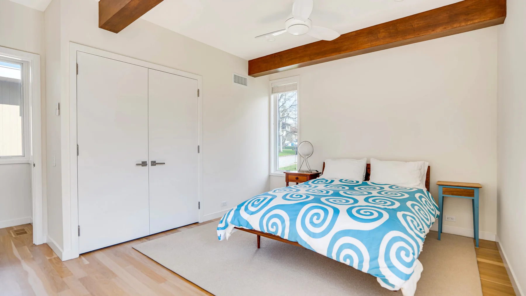 Un dormitorio con una cama cubierta con una colcha estampada azul y blanca.