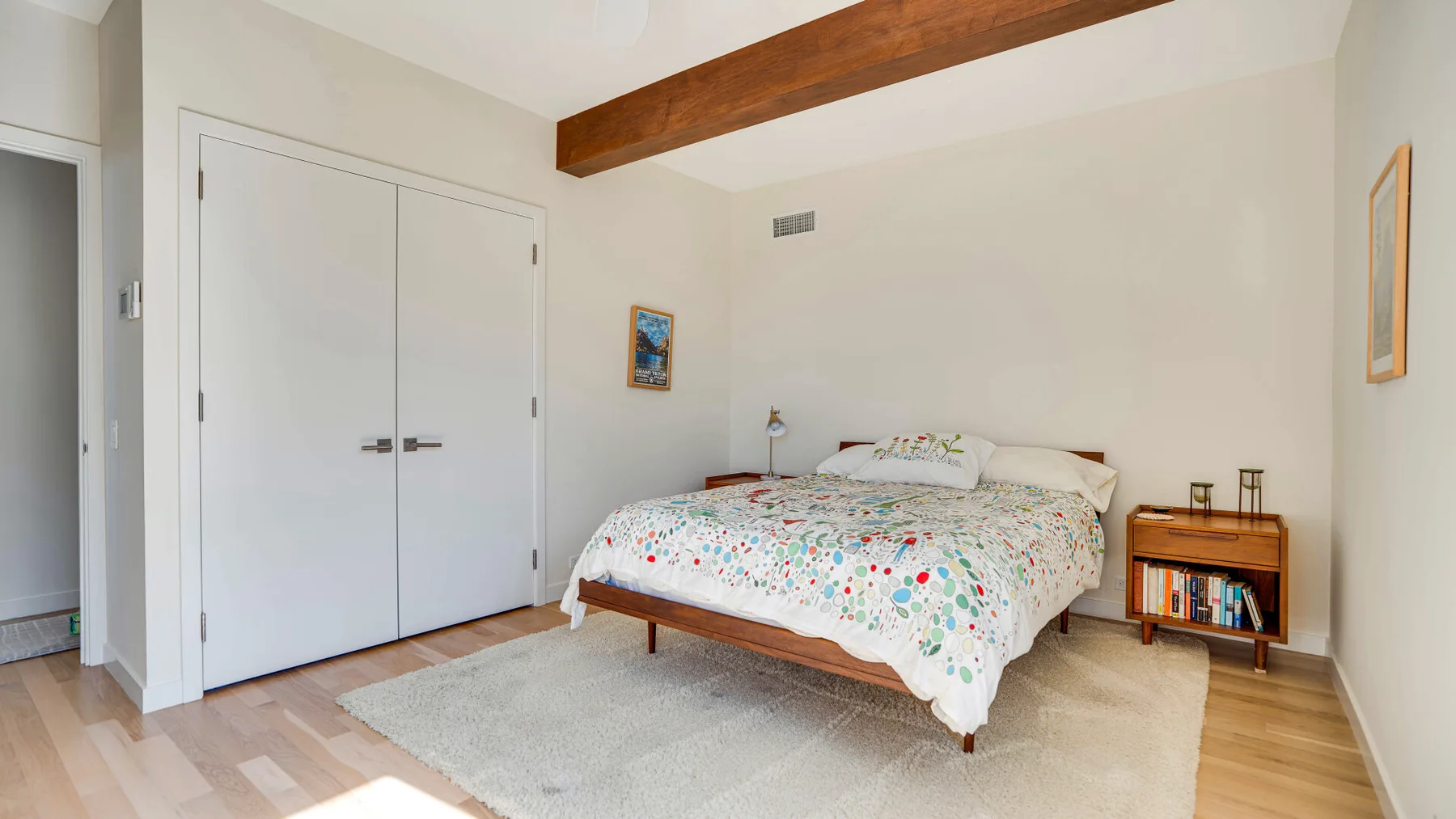 Un dormitorio con una cama cubierta por una colcha de colores y estampados.
