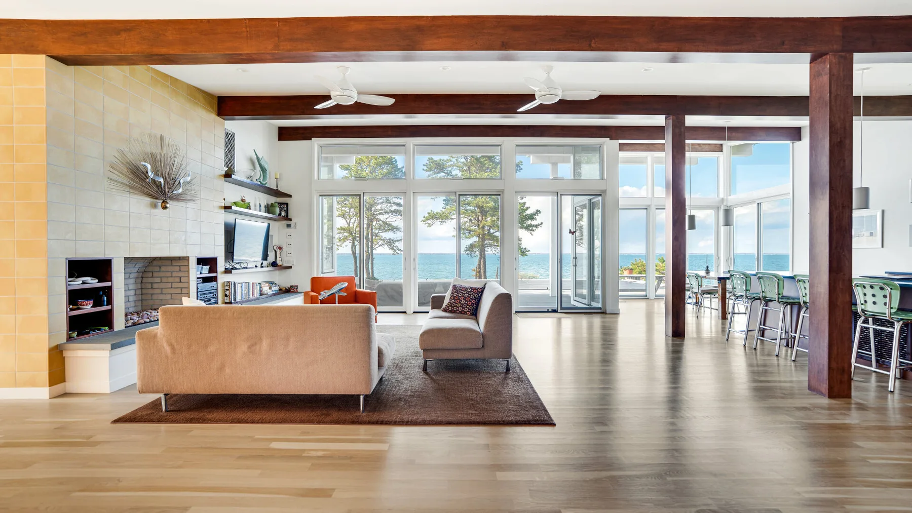 Una luminosa sala de estar diáfana con asientos y grandes ventanas con vistas al agua.