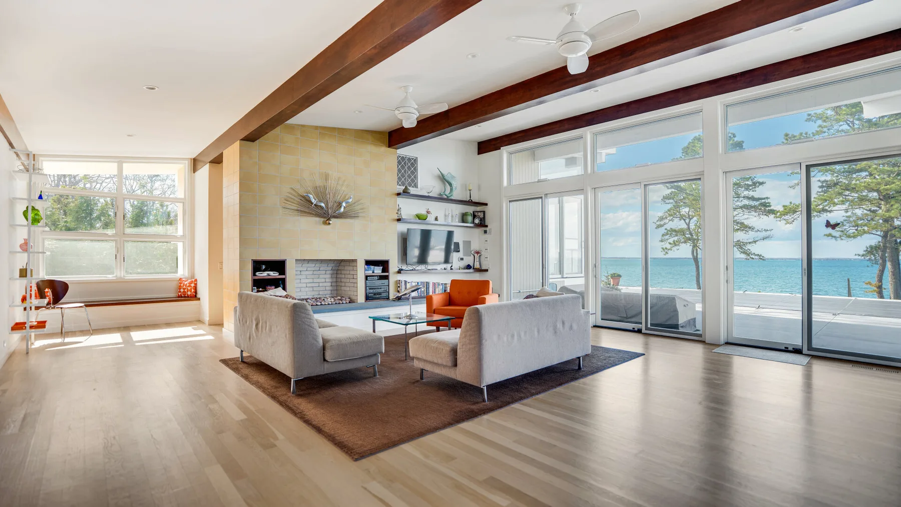 Una sala luminosa con asientos y grandes ventanas con vistas al agua.