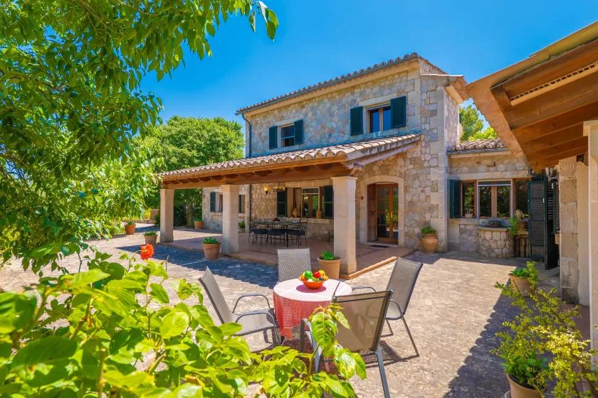 A stone house with a covered patio and outdoor seating.