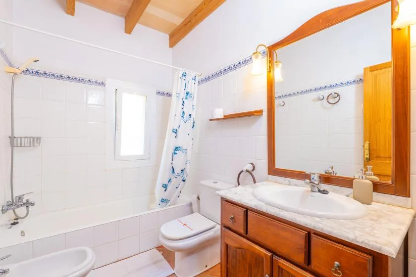 A tiled bathroom with a bathtub, sink, and large wall mirror.