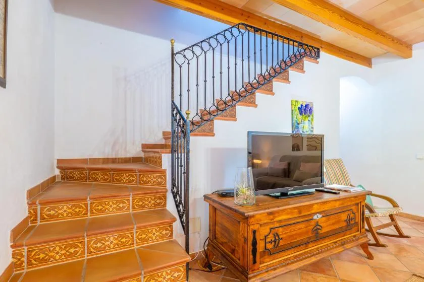 A living area with a television beneath a staircase.