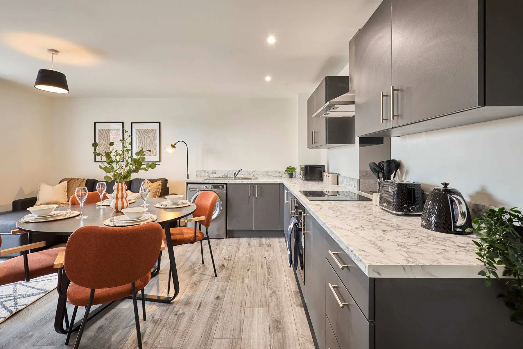 A modern kitchen with a dining table and gray cabinetry.