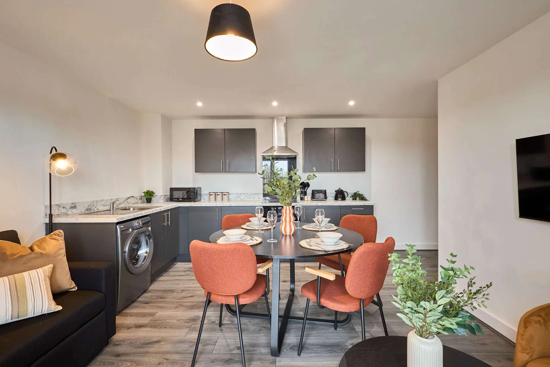 An open-plan kitchen and dining area with a table set for a meal.