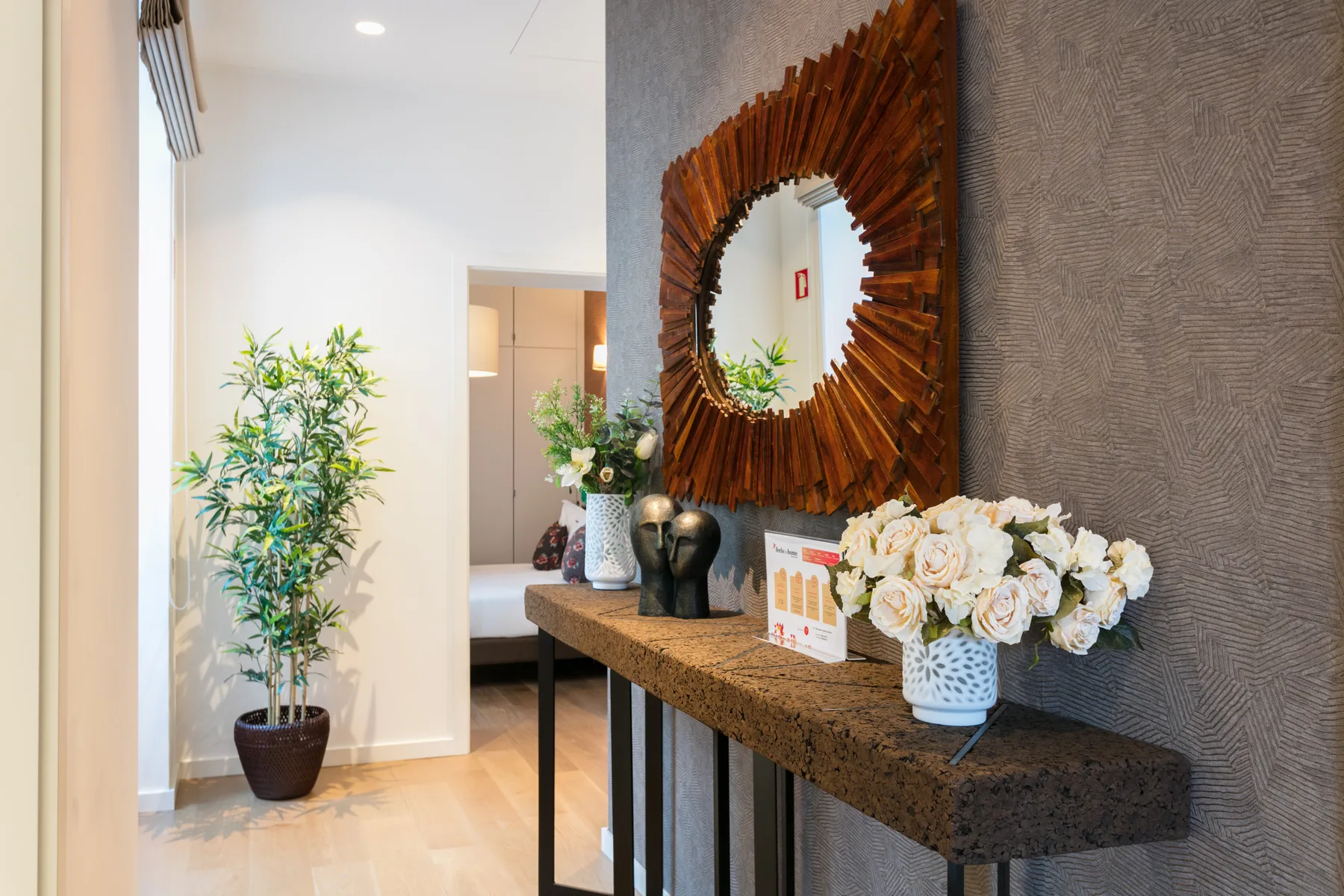 A bright entry area features a console table, decorative mirror, and potted plant.