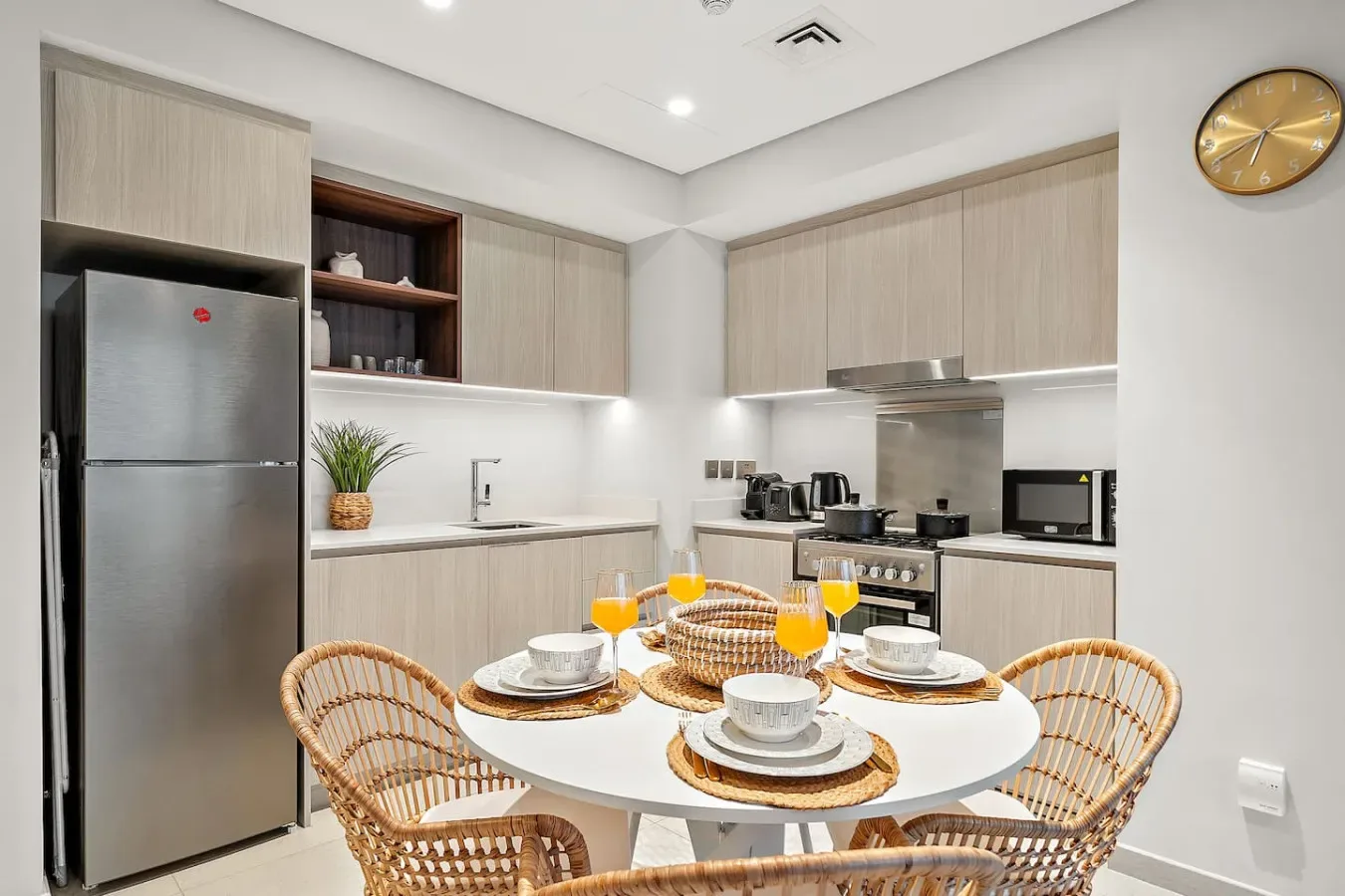 Una luminosa cocina con comedor, mesa redonda y asientos tejidos.