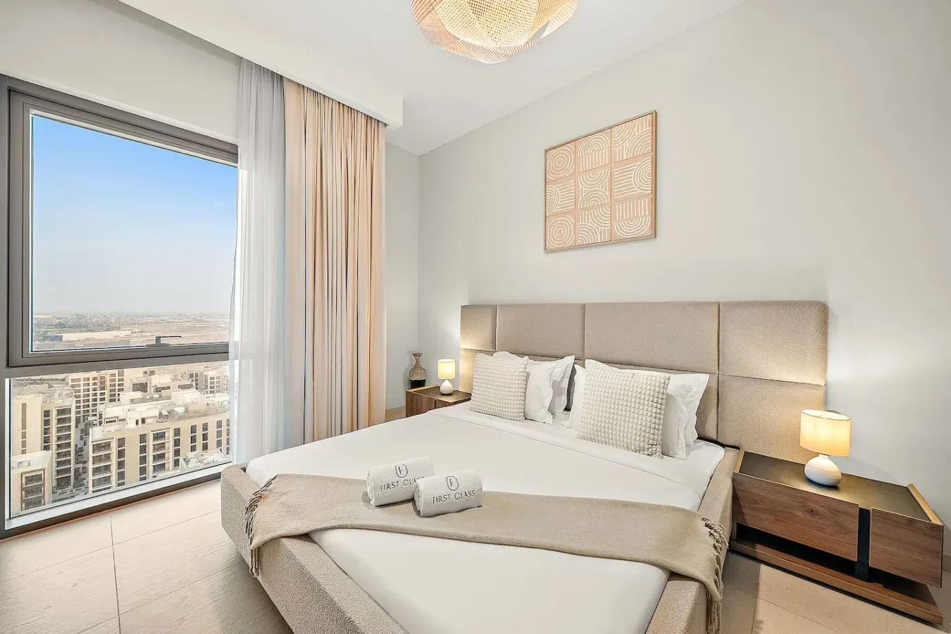 Un dormitorio luminoso con una cama junto a una ventana amplia con vistas a la ciudad.