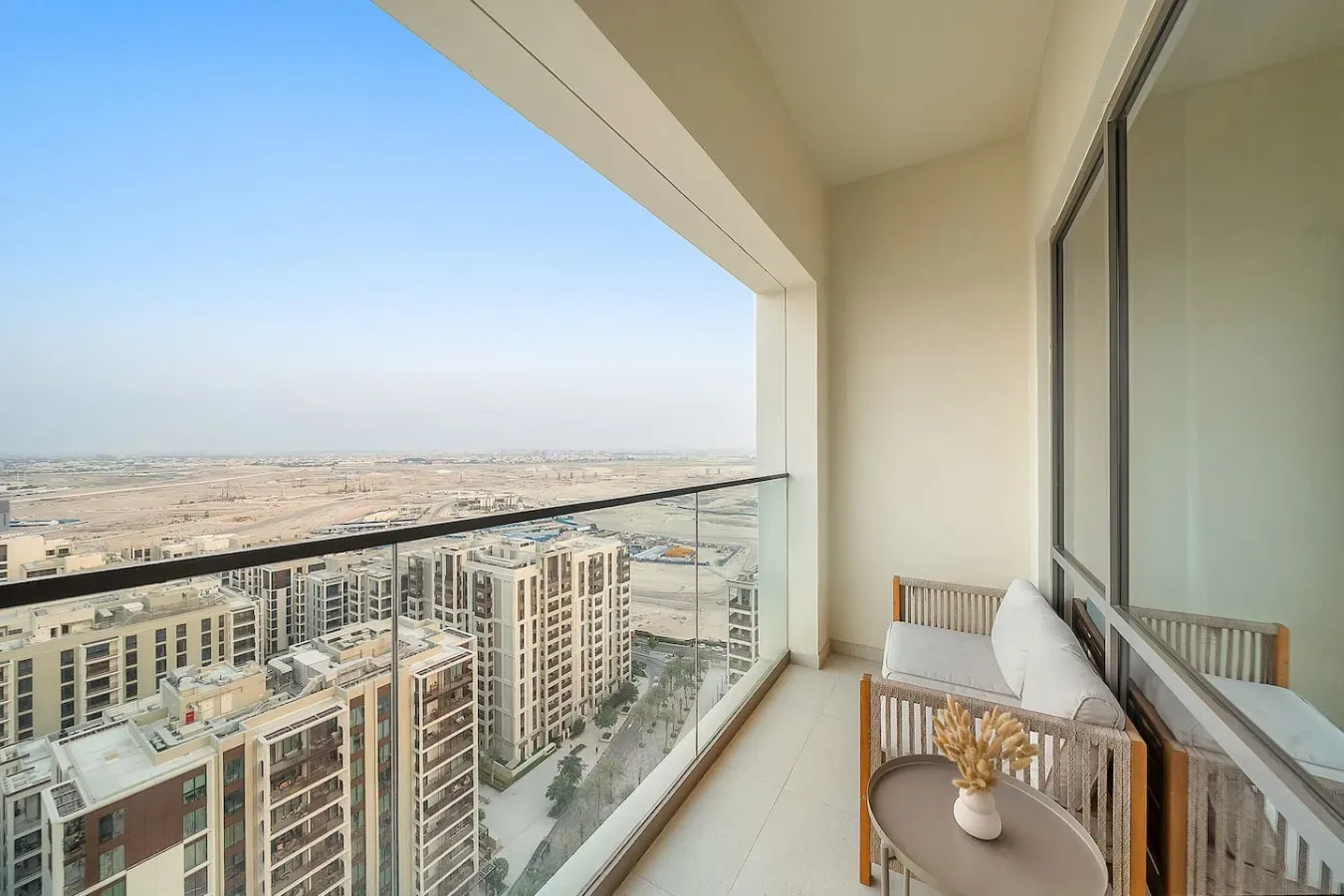 Un balcón con asientos ofrece vistas de edificios de apartamentos y un amplio paisaje.