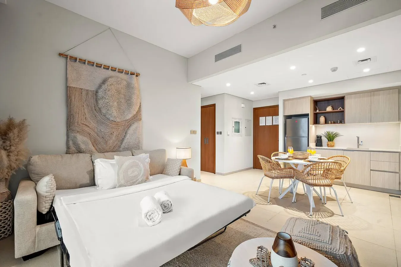 Una luminosa sala de estar y comedor diáfanos con cama y cocina pequeña.