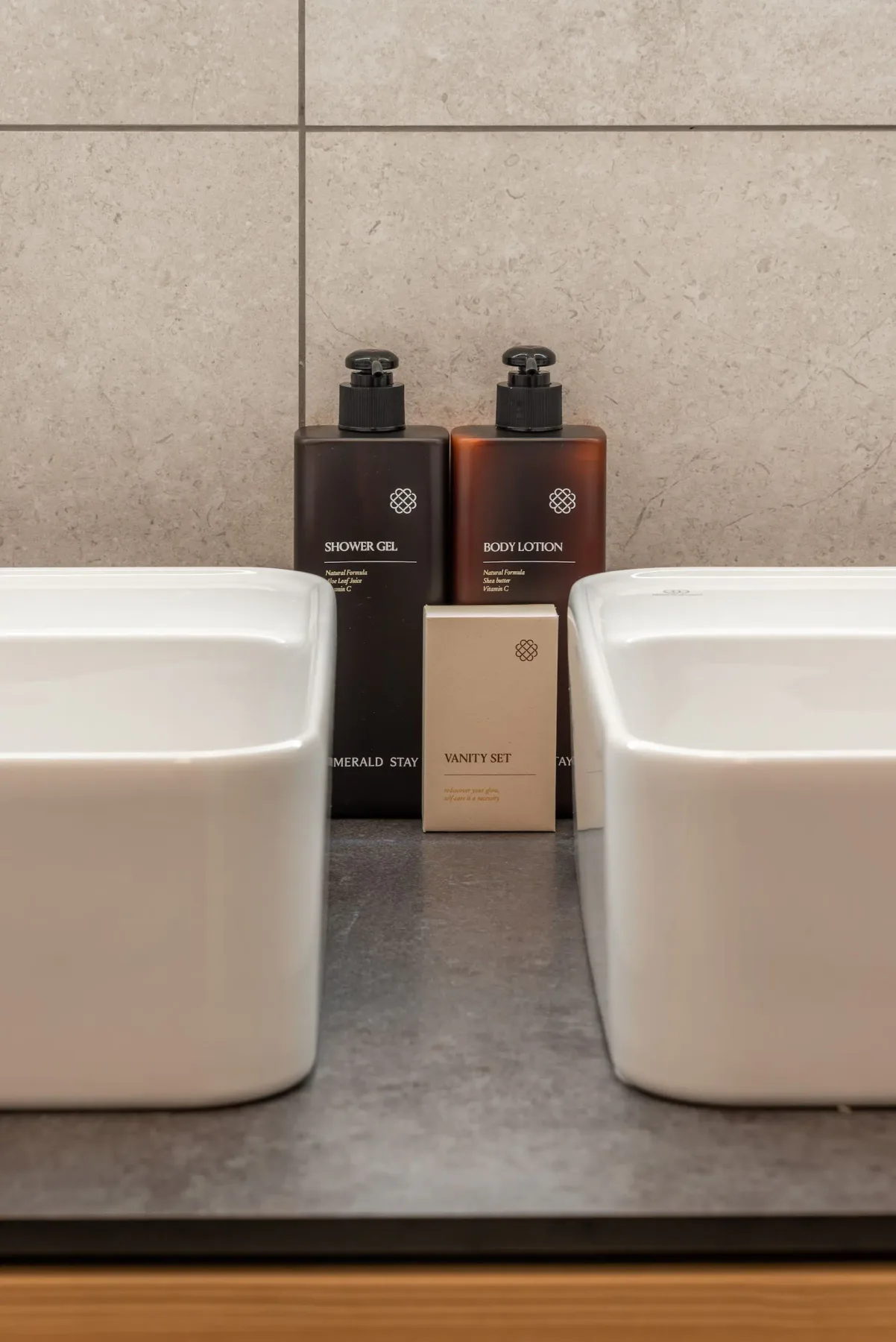 Modern bathroom with double sinks, a large illuminated mirror, wooden shelving, and a glass-enclosed walk-in shower.