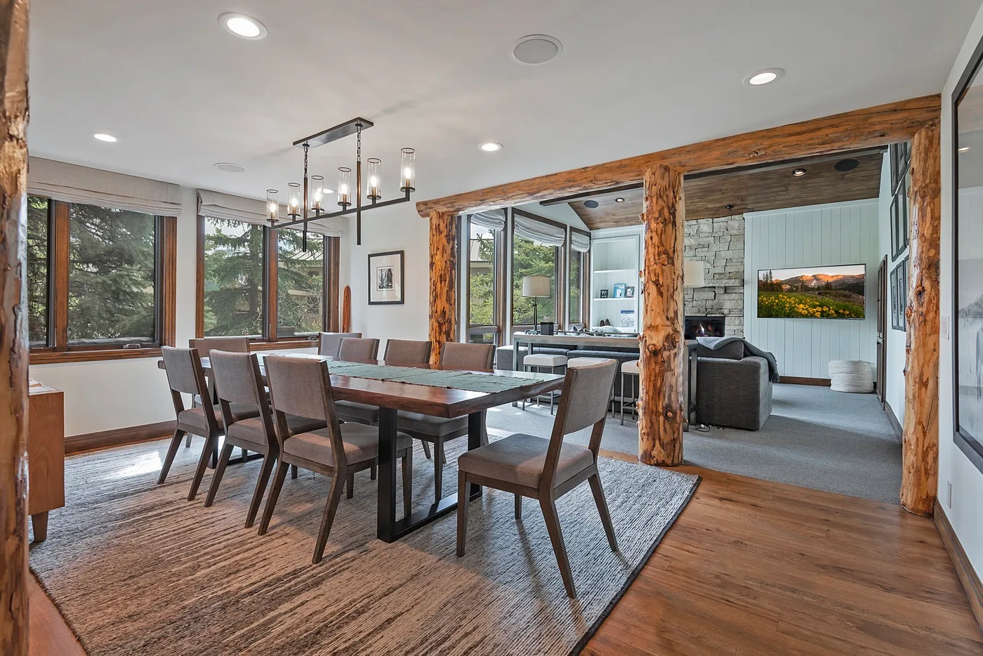 A dining area opens into a living room, with large windows along the wall.