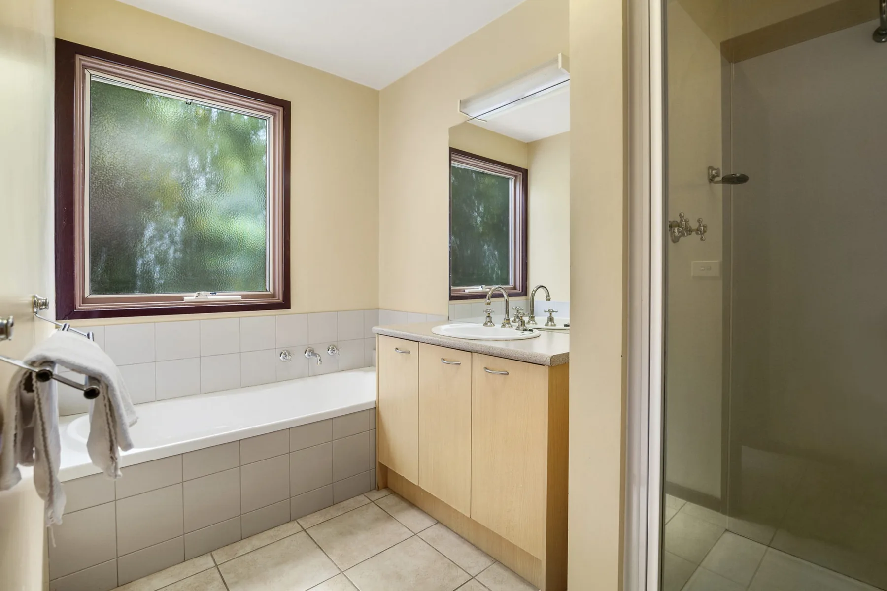 Un baño con bañera, lavabo y armario con espejo.