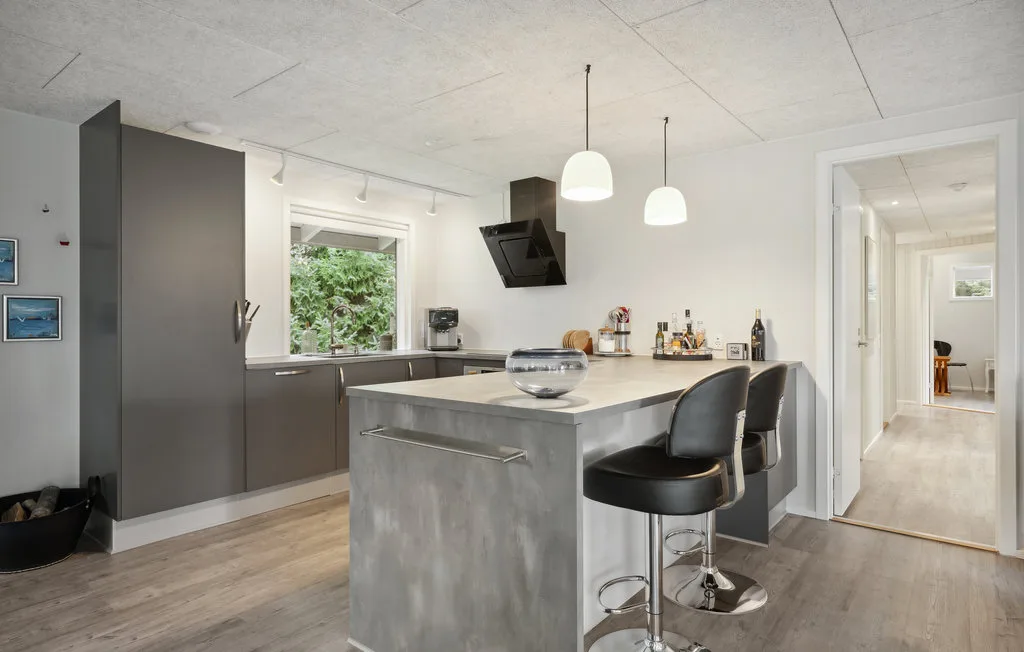 Una cocina moderna con una isla central y luces colgantes.