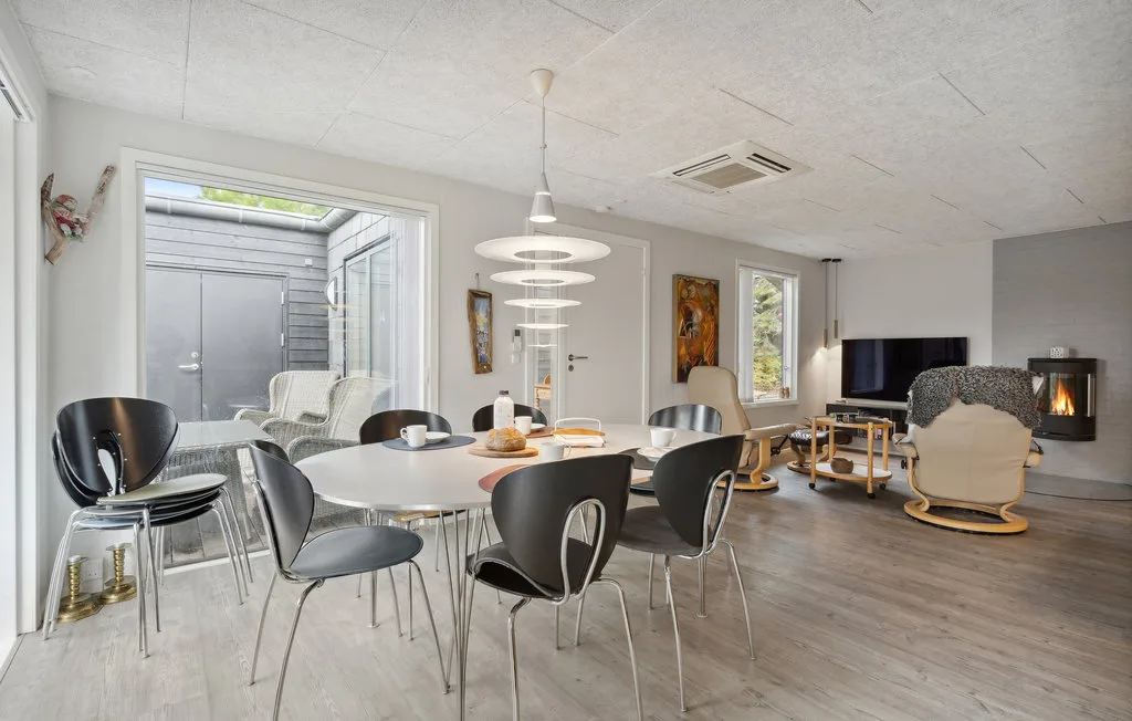 Una luminosa sala de estar y comedor con mesa, asientos y chimenea.