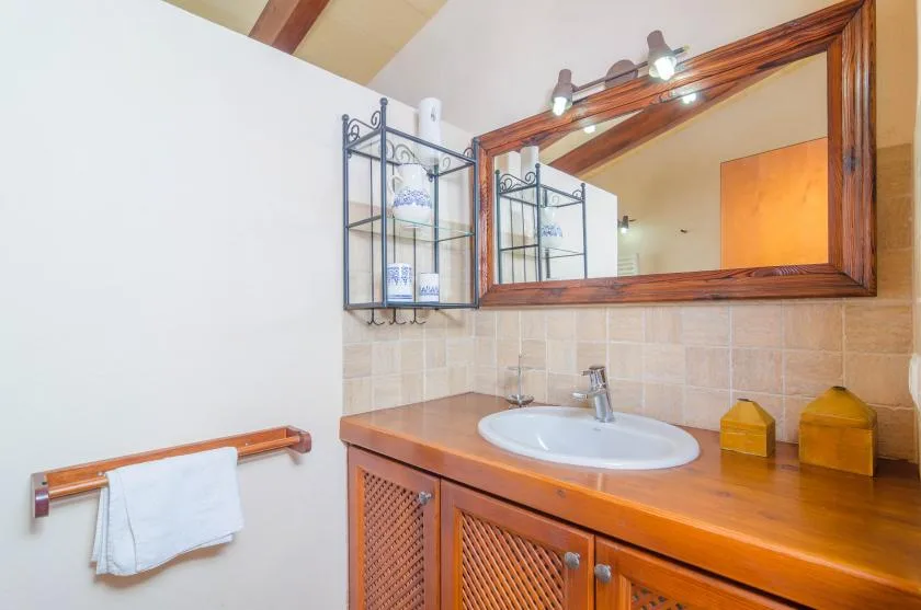 A bathroom vanity with a sink sits beneath a large framed mirror.