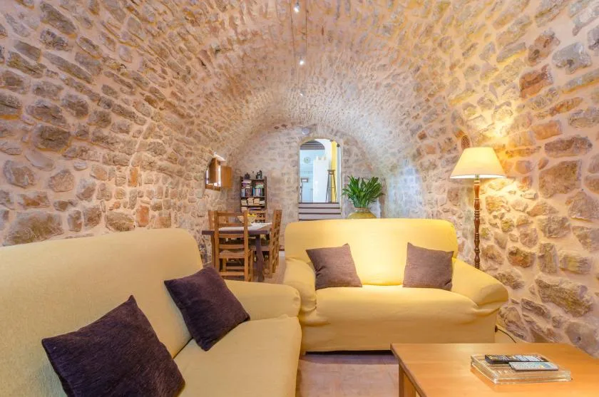 A stone-walled living room with seating and a wooden coffee table.
