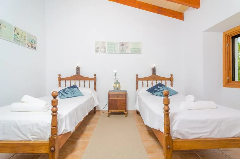 A bedroom with two single beds and a small table between them.