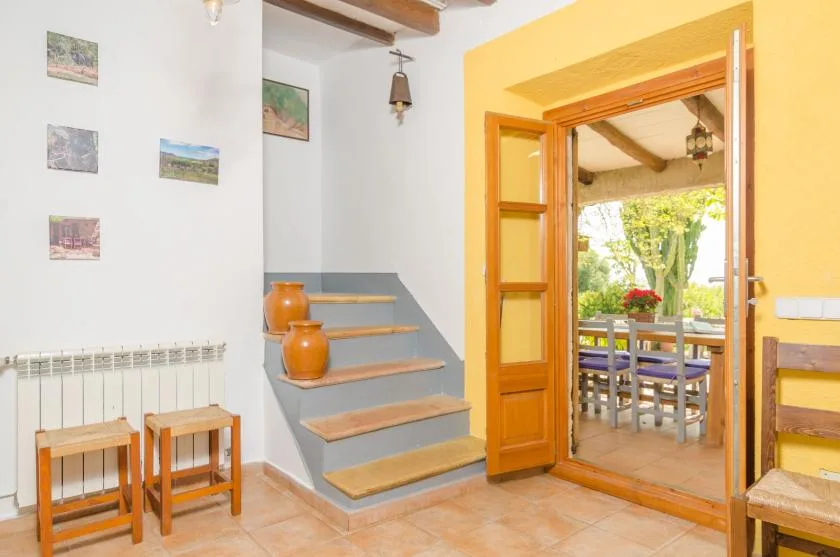 An interior entryway with short steps leading through an open wooden doorway to a dining area.