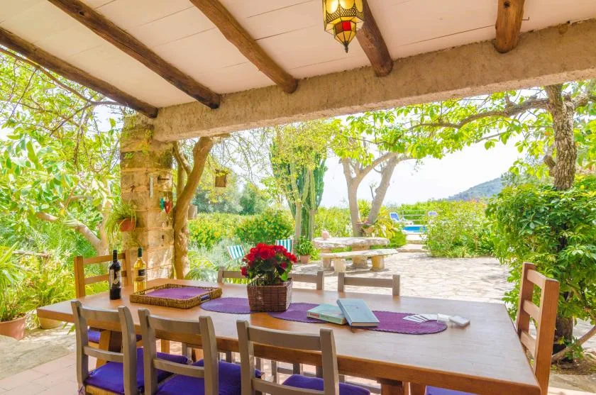 A covered outdoor dining area opens onto a garden patio.