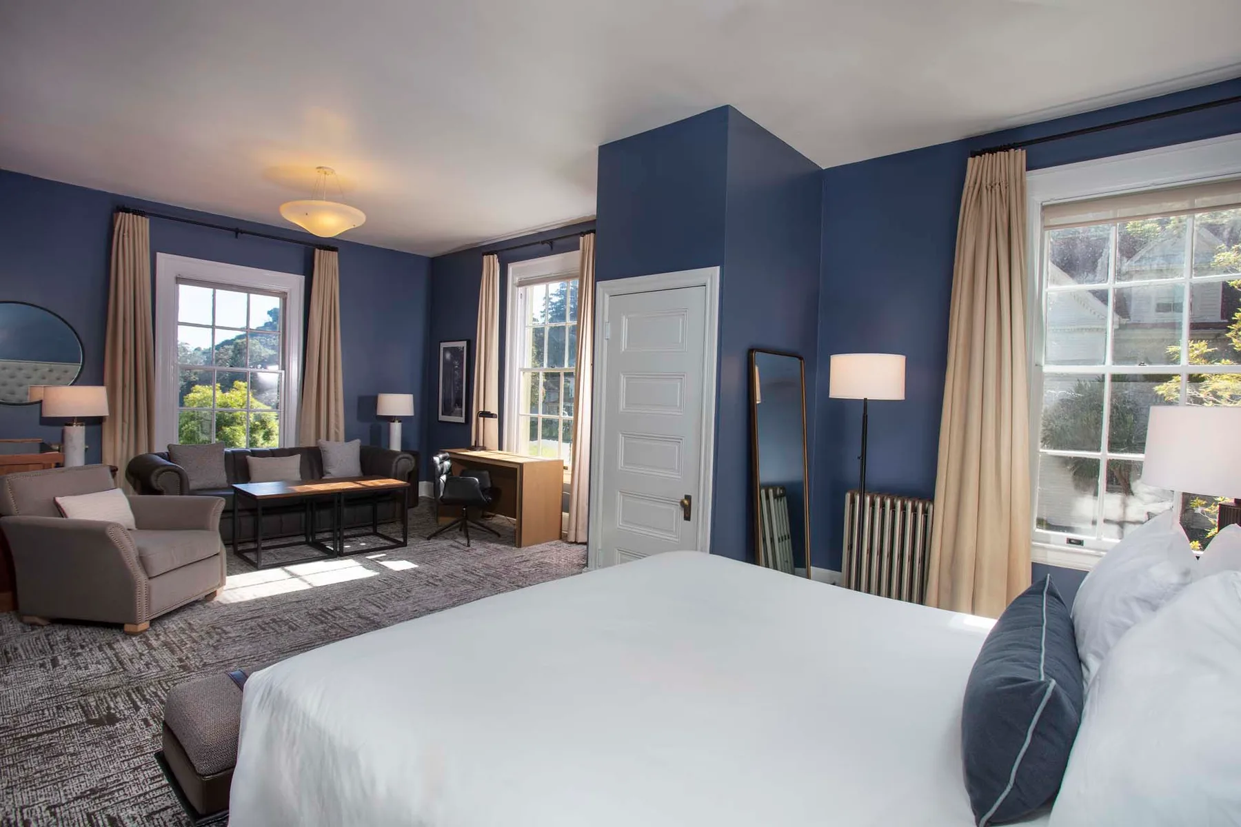 Guest room with king bed, sitting area and desk
