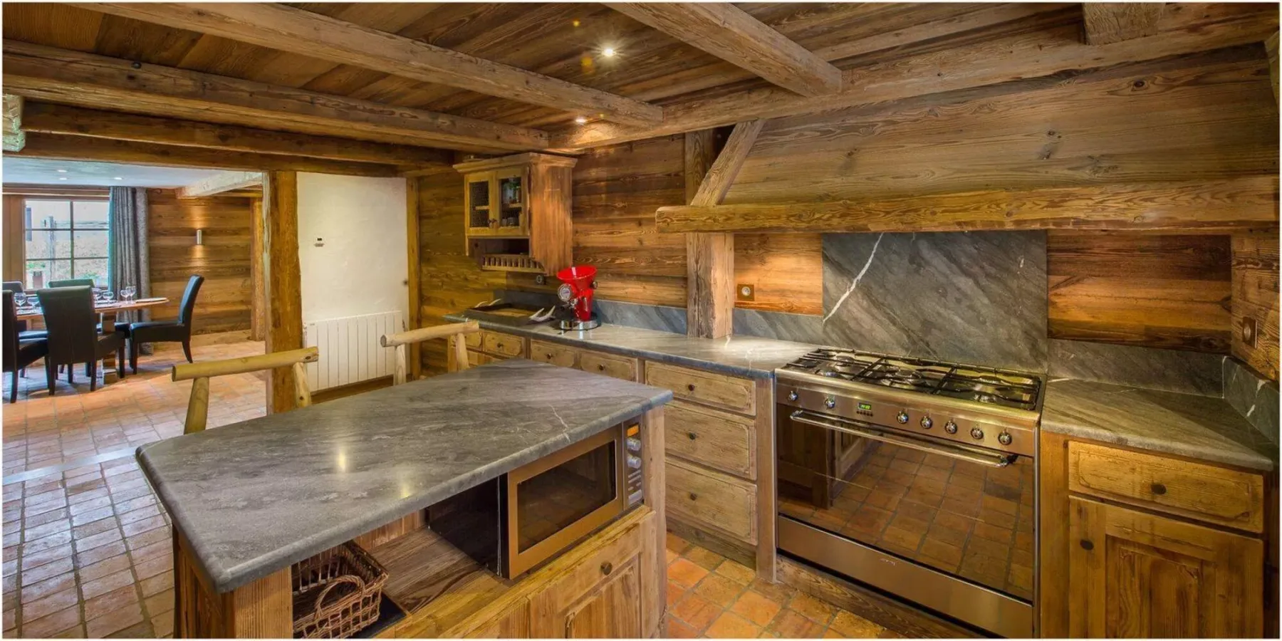 A rustic kitchen with wooden cabinetry and a large central island.