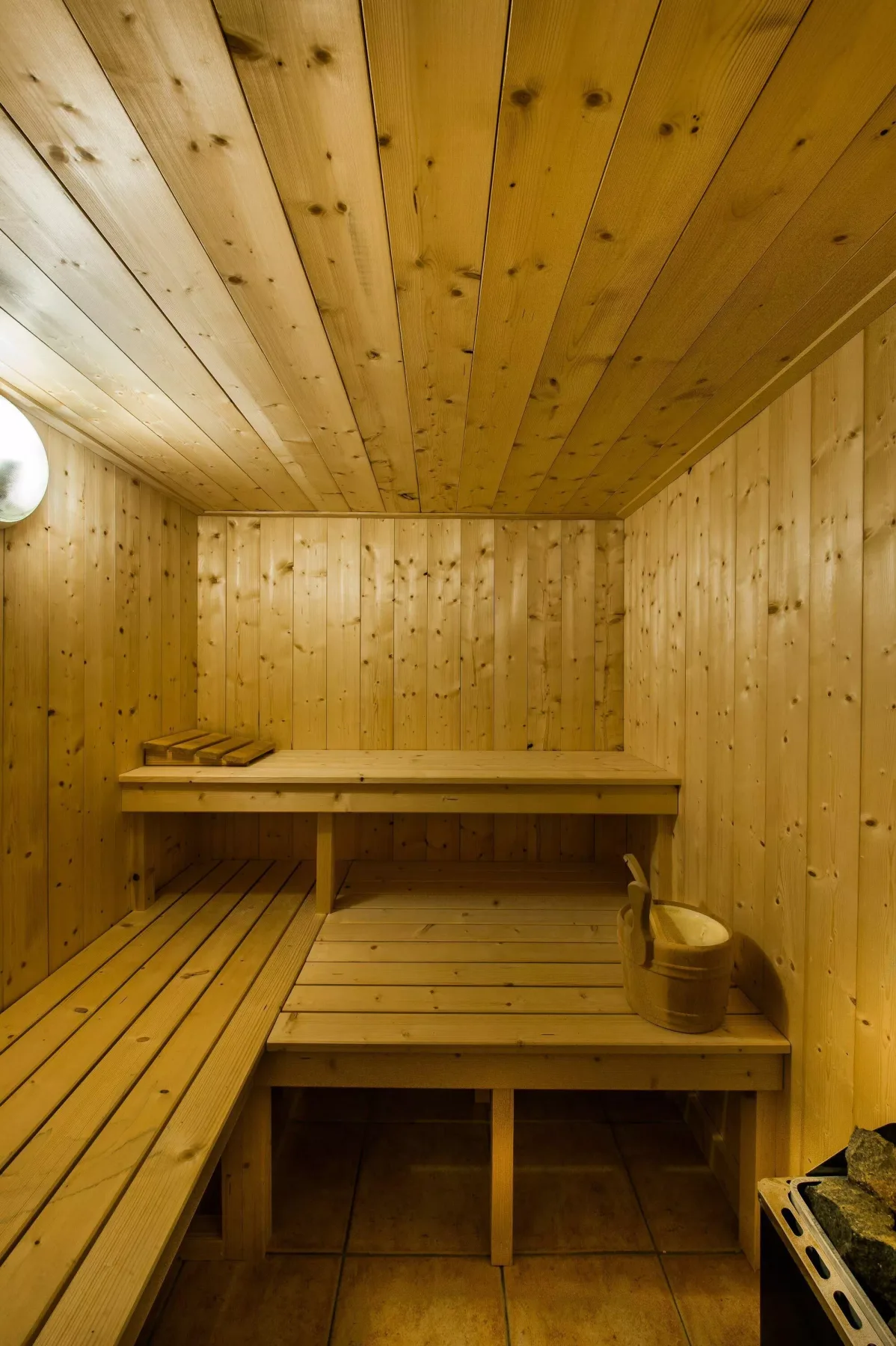 A wood-paneled sauna with tiered wooden seating.
