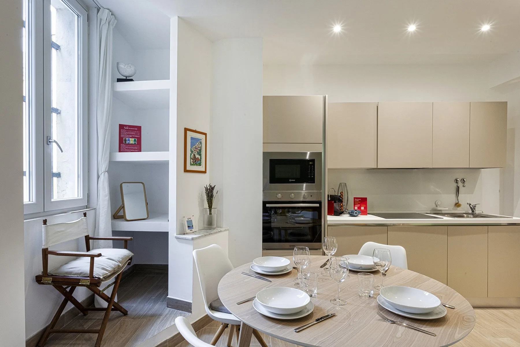 Comedor con la mesa puesta junto a una cocina moderna.