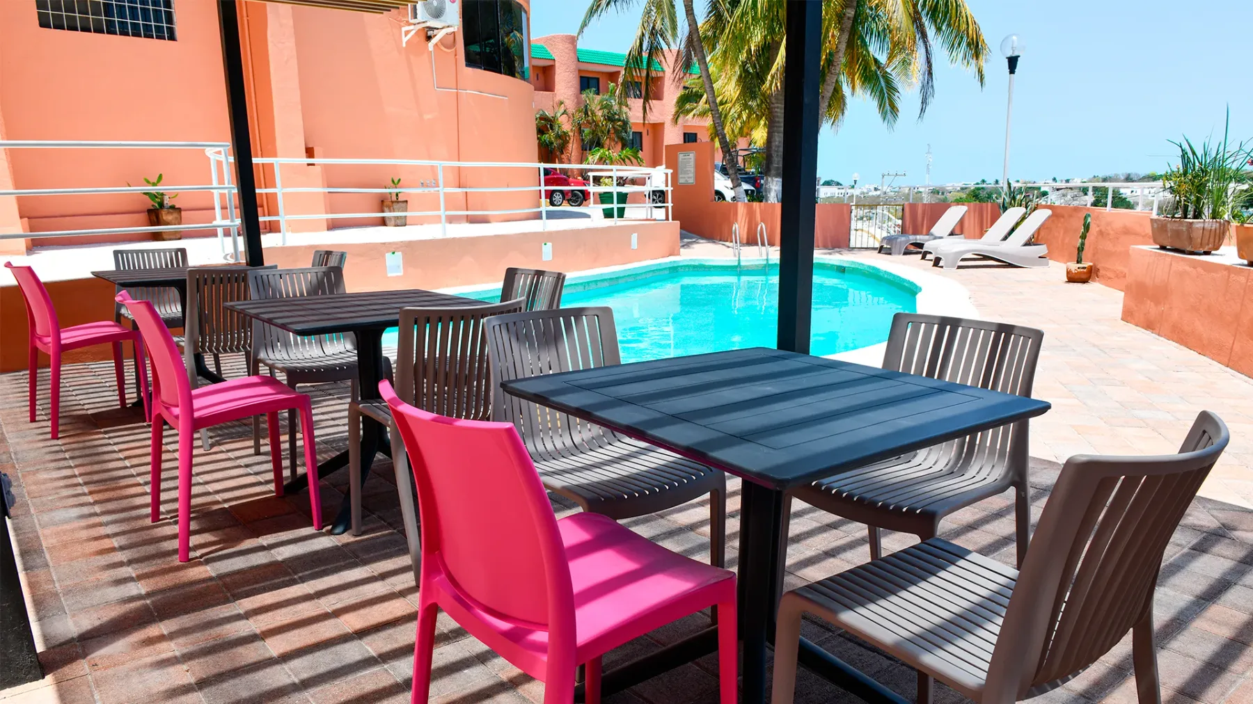 Patio junto a la alberca con mesas y sillas