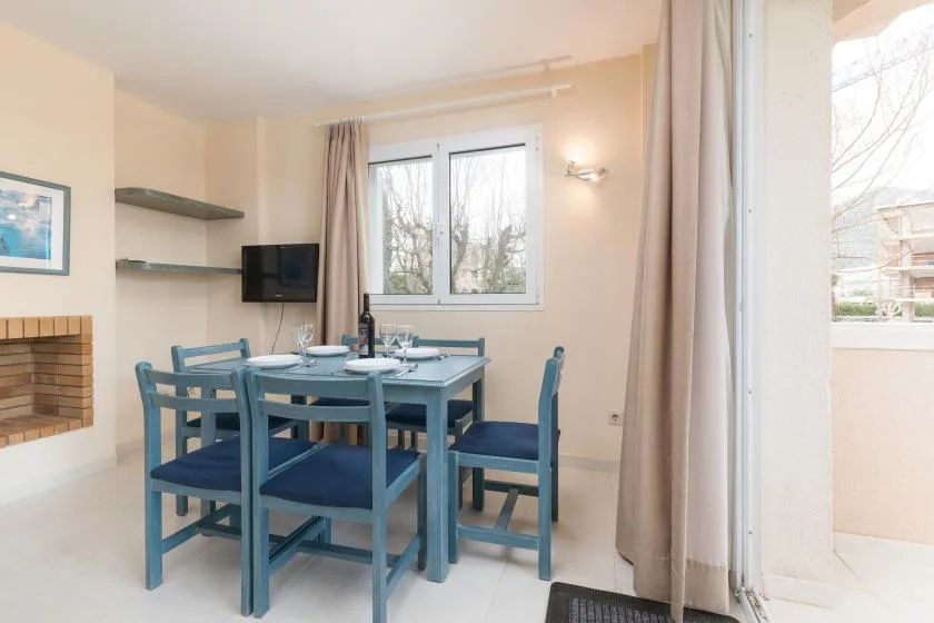 A dining area with blue seating, a table, and a window.