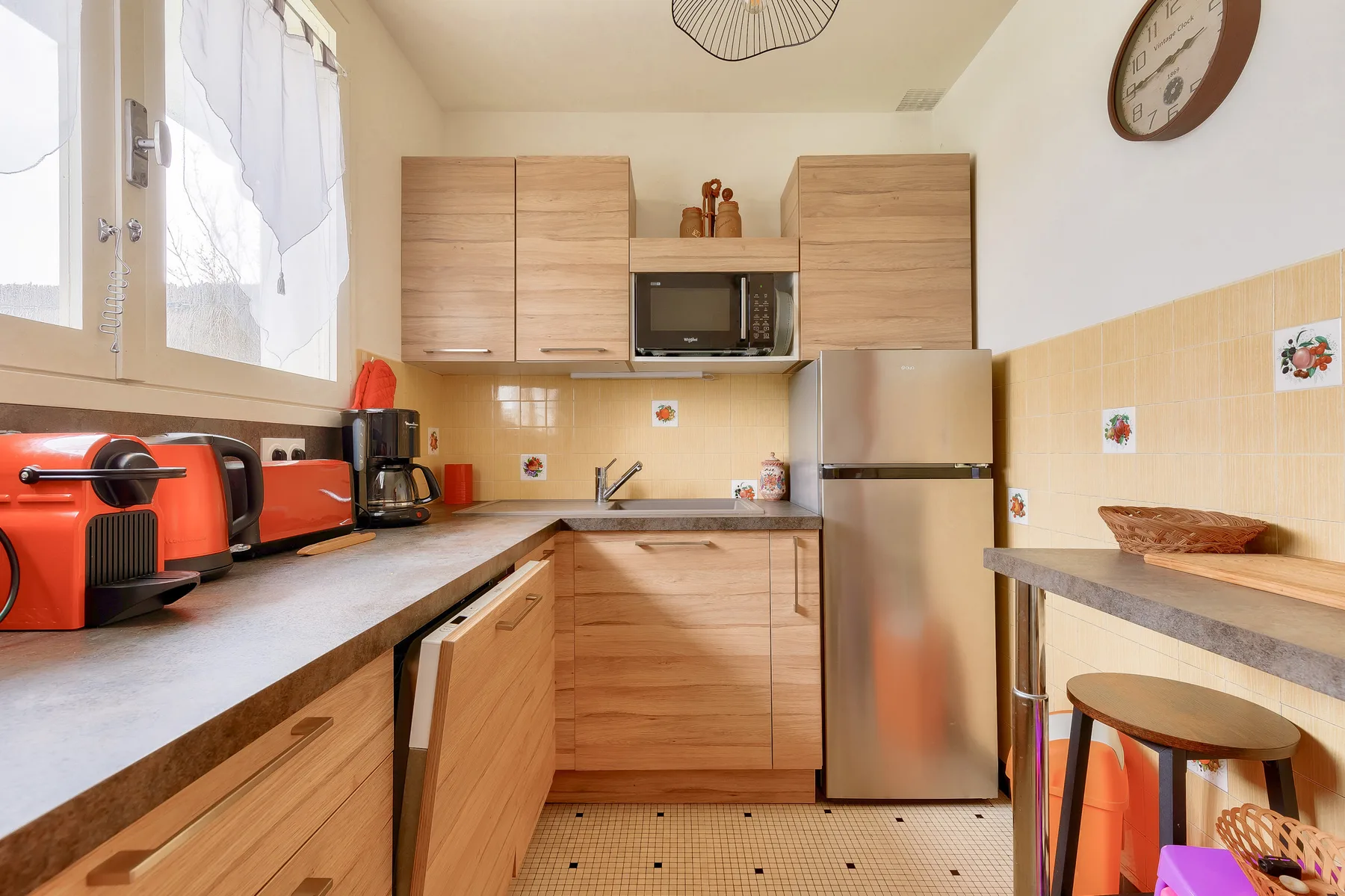A bright kitchen with wood cabinetry, a countertop, and stainless-steel appliances.
