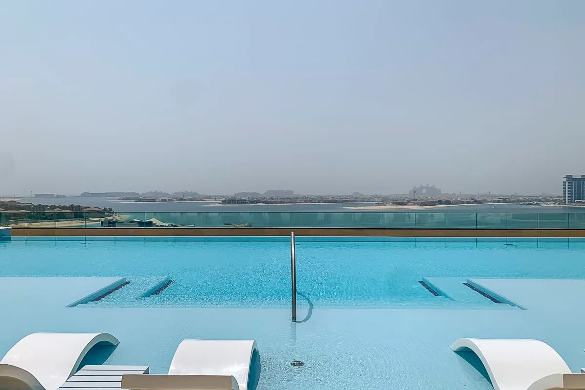 A rooftop pool overlooks the waterfront, with lounge seating along the edge.