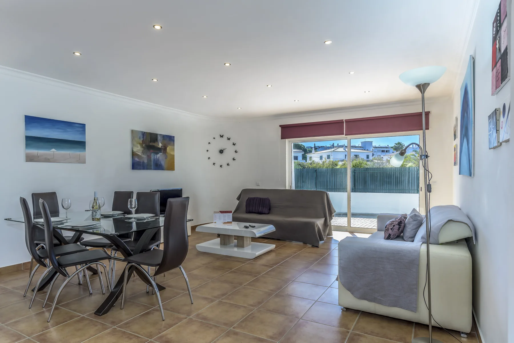 Una luminosa sala de estar y comedor con asientos junto a grandes ventanas.
