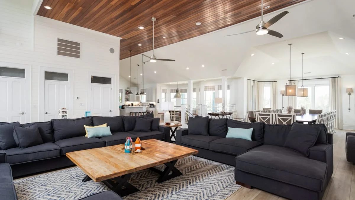 Sala de estar y comedor de concepto abierto, con asientos seccionales y una mesa de centro de madera.