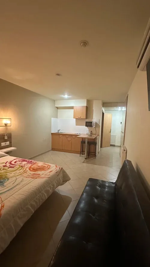 Accommodation with kitchenette, bed and sitting area
