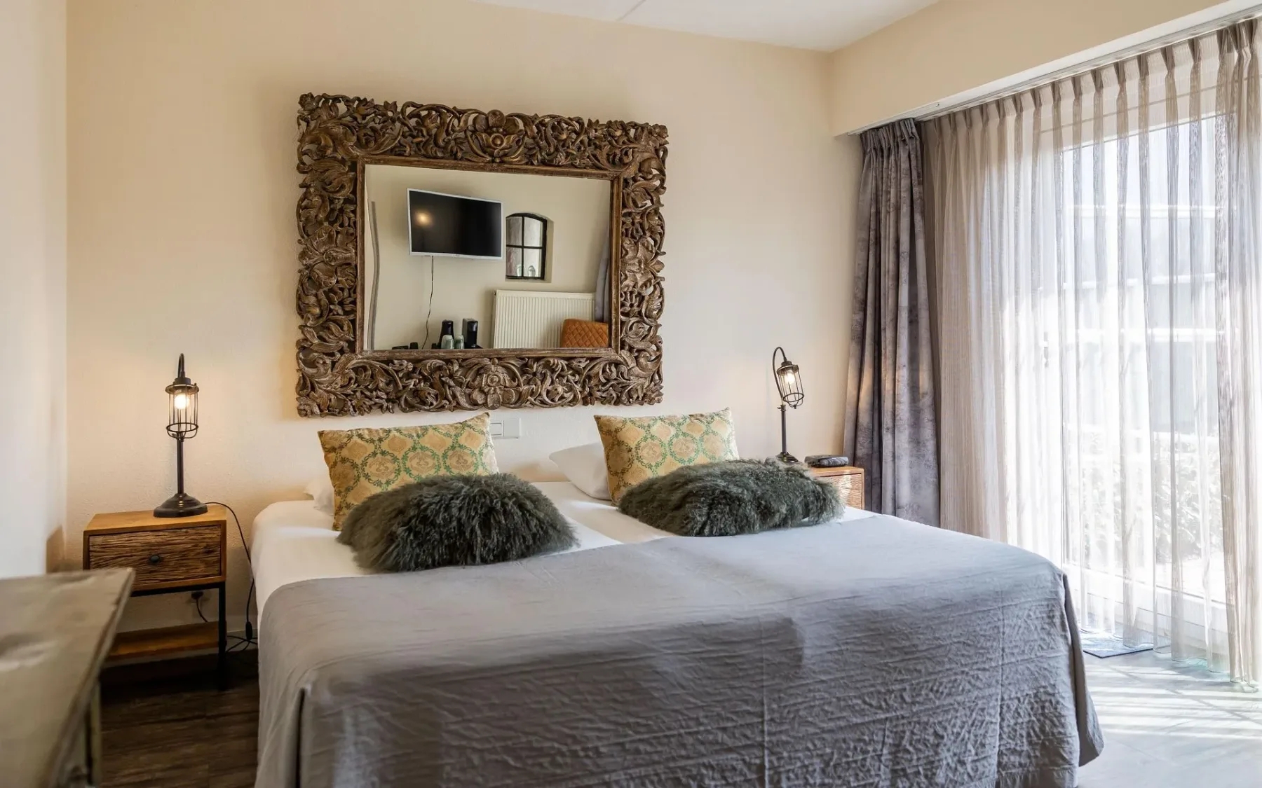 Dormitorio con un espejo grande encima de la cama.