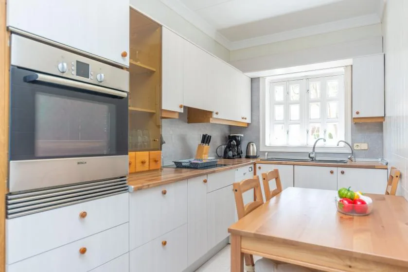 A bright kitchen with a dining table beside the counter and window.